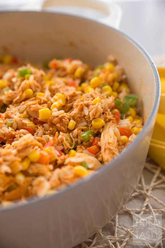 Chicken Taco Rice Salad // Want an easy weeknight meal that the whole family will love? Try this super family friendly flavor packed chicken dish on your next menu! Serve it atop Fritos corn chips, sprinkled with fresh cheddar cheese and you've got an out of this world dinner! One to be made again and again! | Tried and Tasty