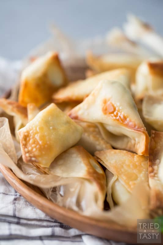 Plate of wontons with green onion garnish on a linen napkin