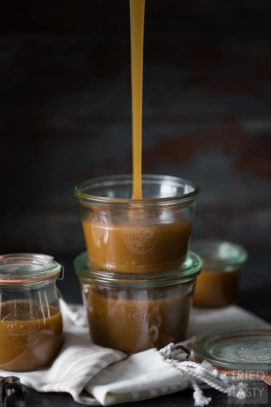 Glass jar being filled with homemade caramel