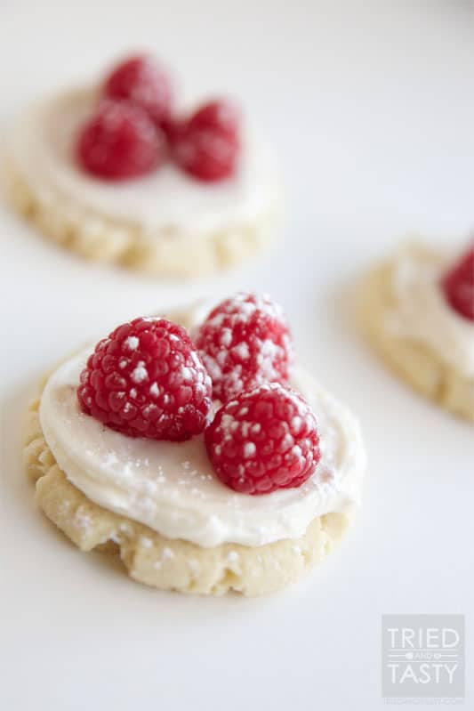 Raspberry Sugar Cookie Tart // A delicious sugar cookie topped with a layer of cream cheese frosting, a few raspberries and lightly dusted with powdered sugar. | Tried and Tasty
