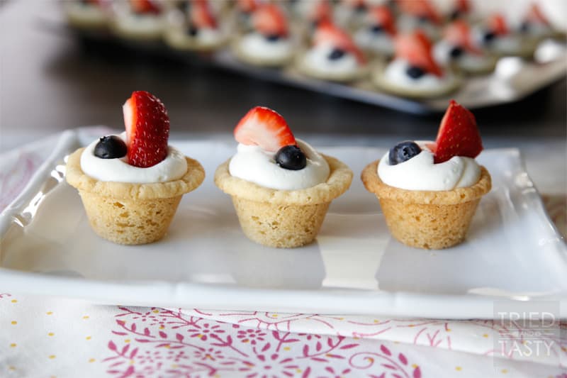Red White & Blue Strawberry Blueberry Sugar Cookie Cups with Coconut Cream Cheese Filling // These scrumptious little treats are perfect party poppers! They are mini, fit right in the palm of your hand, and will be gobbled up in no time. With the tiniest hint of coconut, you'll be left wanting more! | Tried and Tasty
