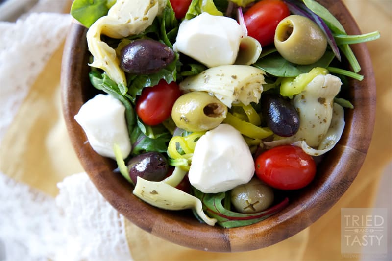 Mediterranean Salad With A Creamy Feta Dressing // The most wonderful Mediterranean Salad featuring the delicious flavors of marinated artichokes, fresh mozzarella, savory olives, and red onion. Finish it off with the most delectable creamy feta dressing for a knockout pairing! | Tried and Tasty