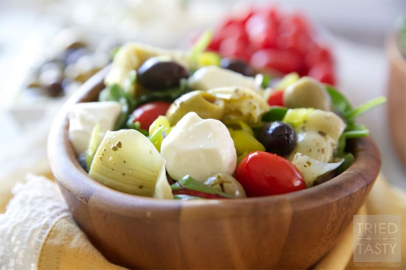 Mediterranean Salad With A Creamy Feta Dressing // The most wonderful Mediterranean Salad featuring the delicious flavors of marinated artichokes, fresh mozzarella, savory olives, and red onion. Finish it off with the most delectable creamy feta dressing for a knockout pairing! | Tried and Tasty