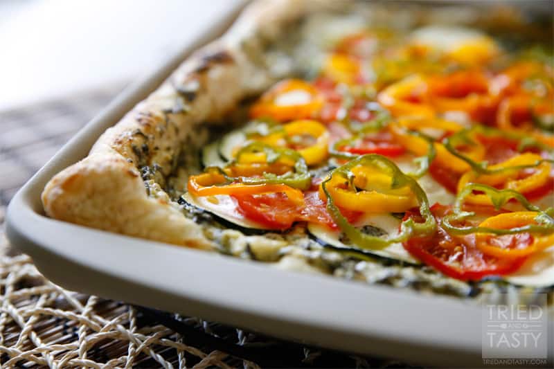 Spinach & Artichoke Veggie Pizza // A delicious way to use up some of your favorite seasonal vegetables. For the gardeners, you can grab most all of these veggies from your backyard. For the non-gardeners run to your nearest farmer's market & plan this pizza for your next get together! | Tried and Tasty