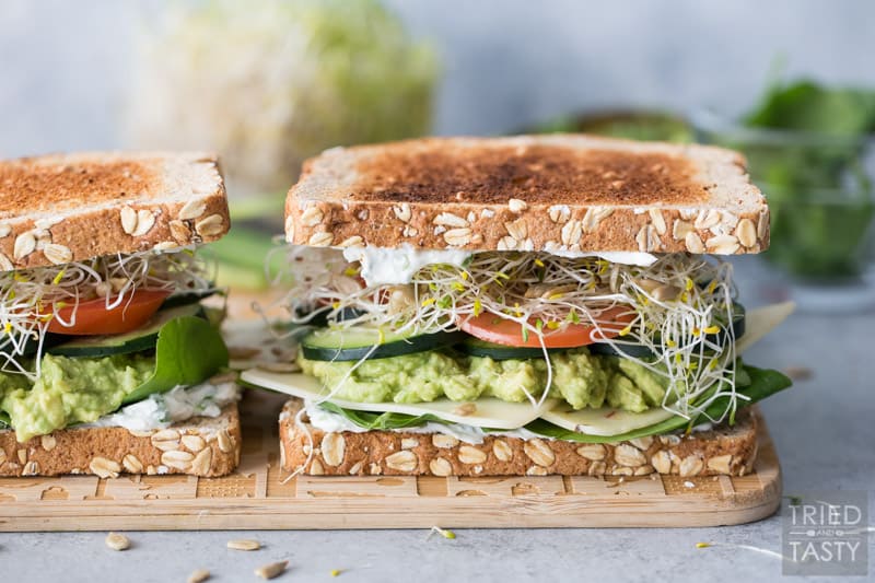 A close up photo of a Veggie Sandwich on a wooden cutting board