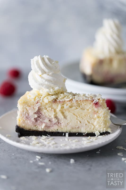 Slice of Cheesecake Factory White Chocolate Raspberry Truffle Cheesecake on a white plate
