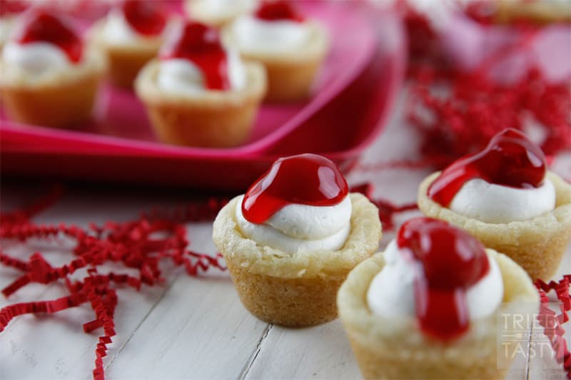 Mini Cherry Cheesecake Sugar Cookie Cups // These delicious little bite-sized bits of heaven are perfect for Valentine's Day! They are mini, fit right in the palm of your hand, and will be gobbled up in no time. With the tiniest hint of coconut, you'll be left wanting more! | Tried and Tasty