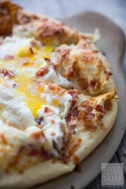 Breakfast Pizza // Make breakfast fun with this delicious pizza! Eggs, bacon and cheese + a crust is all you need. Great the morning of and also still tasty as leftovers! | Tried and Tasty