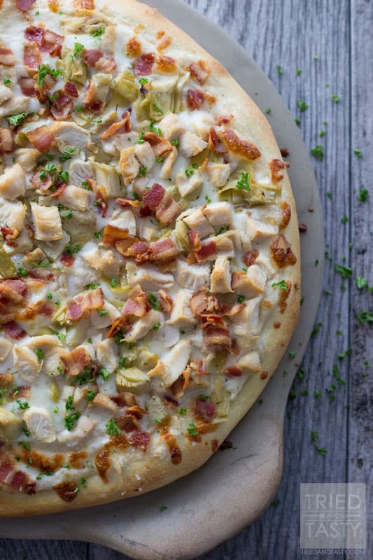 Chicken Bacon Artichoke Alfredo Pizza // One of the best pizza combinations out there. Super simple to throw together, but packed with great flavor. Prepare a delicious crust and top with the best of the best. This pizza makes for a great lunch or dinner - and even delicious as leftovers! | Tried and Tasty