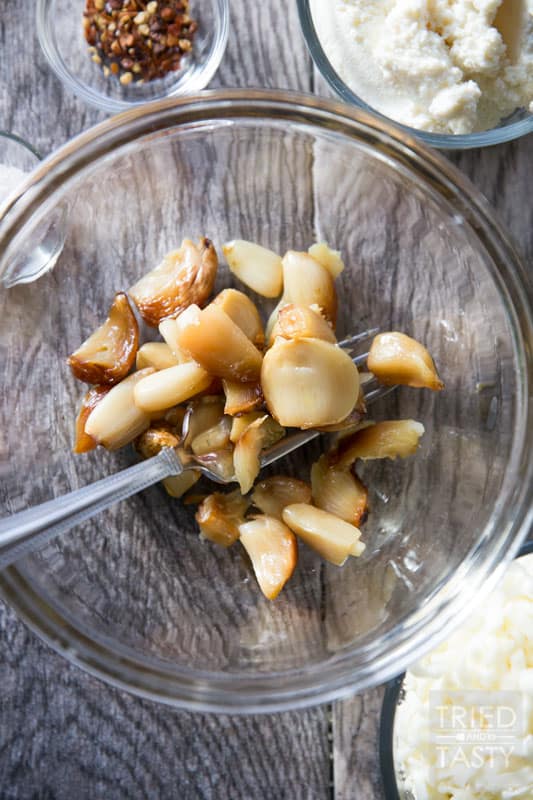 Roasted Garlic Pizza // You won't believe the flavor explosion that this pizza brings to the table. Made with three bulbs of fresh roasted garlic, it's a flavor-packed cheesy delight you're sure to love! | Tried and Tasty