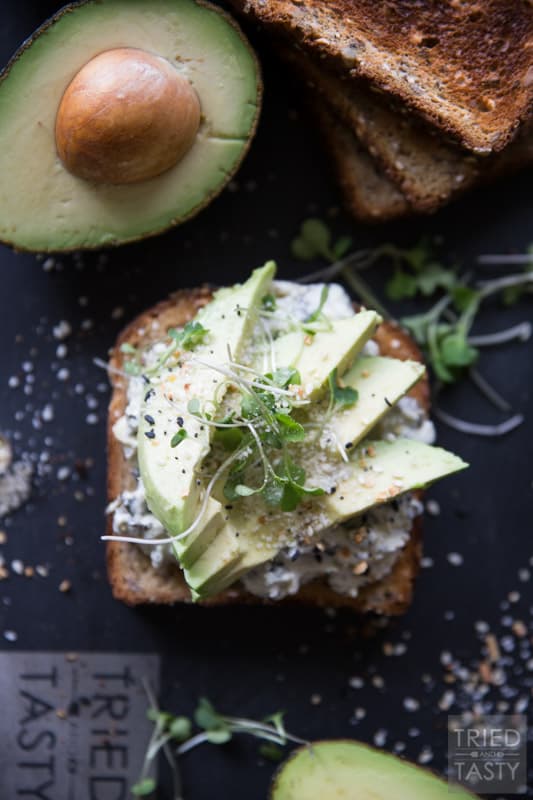 Savory Avocado Toast // This quick and easy snack that could double as breakfast or triple as lunch is simple to make & packed with nutrients! The twist? A smattering of spinach & artichoke dip underneath! | Tried and Tasty