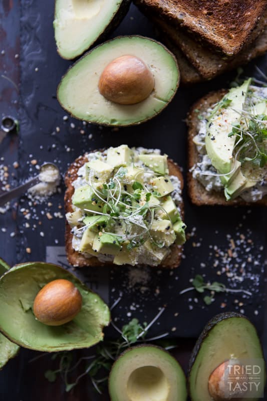 Savory Avocado Toast // This quick and easy snack that could double as breakfast or triple as lunch is simple to make & packed with nutrients! The twist? A smattering of spinach & artichoke dip underneath! | Tried and Tasty